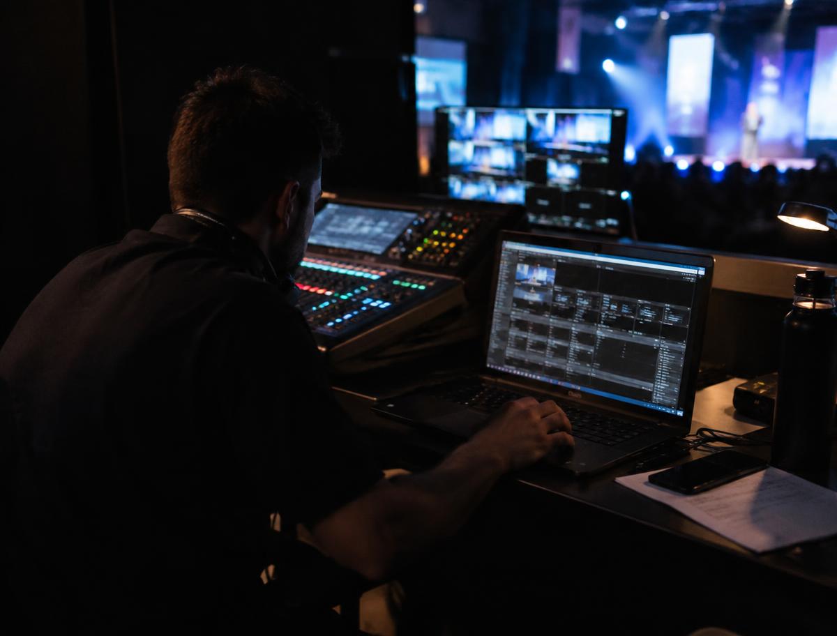 AV technician running the event from a laptop backstage